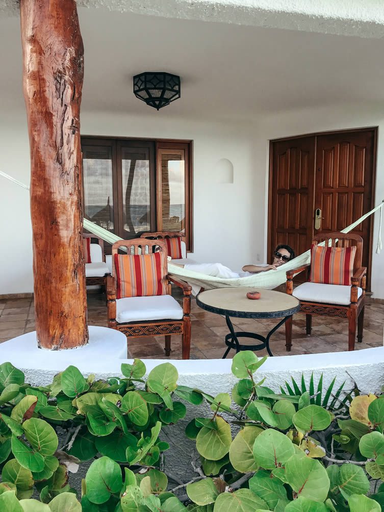 Our large private thatched-roof terrace, decked out in hand-carved furniture and a colourful hammock