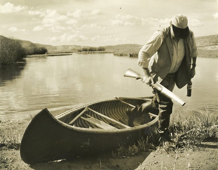 Ernest Hemingway stepping out of a canoe