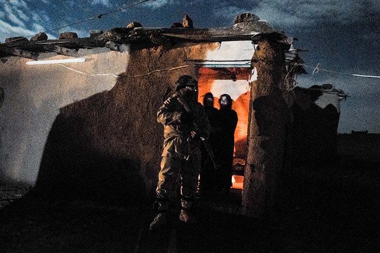 Women sob as soldiers arrest their family