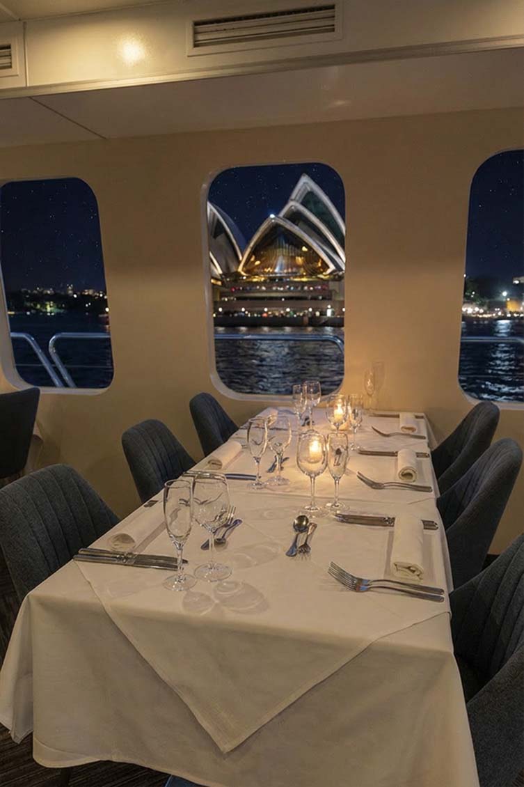 Luxury interiors of the Magistic dinner cruise in Sydney, with the Opera House in the background