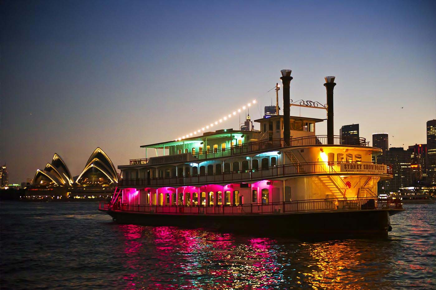 The Sydney Showboats gliding on Sydney Harbour with the Opera House in the background